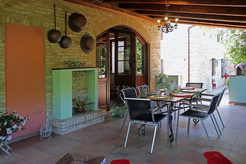 Casa Polly - Veranda mit Tisch und Stühlen ausgestattet