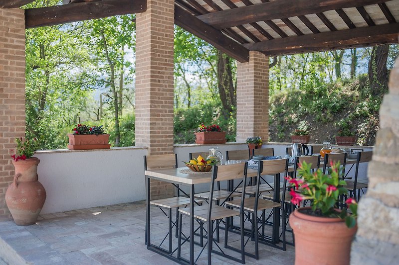 Casale Andrea – Tisch im Freien mit Stühlen zum gemeinsamen Essen