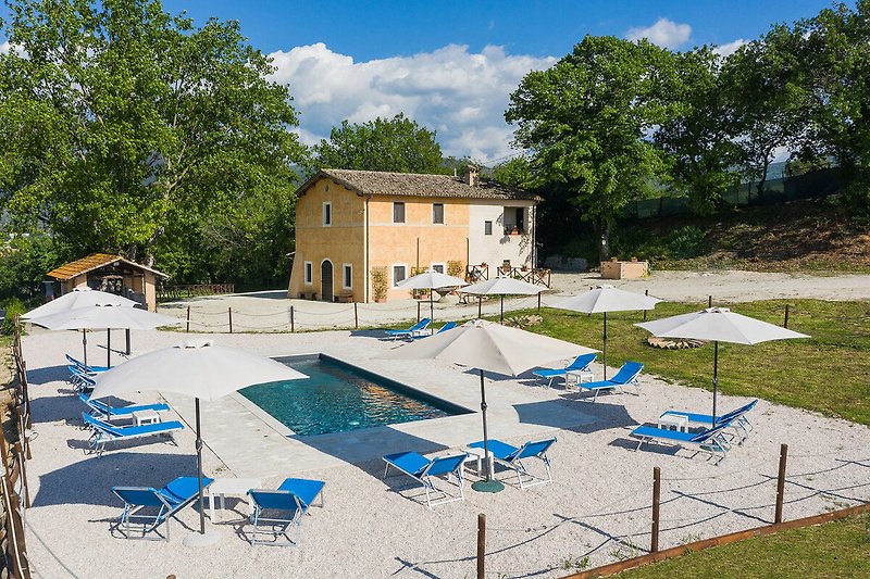 Casale Andrea – Pool ausgestattet mit Sonnenschirmen und Liegestühlen