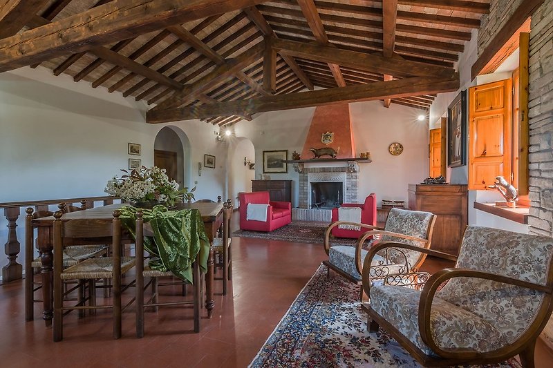 Casale San Francesco - broad living room with wooden beams and fireplace