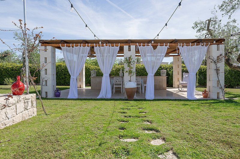 Trulli Le Pupe - Outdoor pergola with dining table and outdoor kitchen