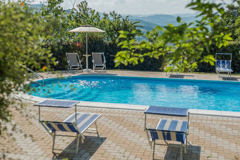 Villa Amata – Poolbereich mit Sonnenliegen und Sonnenschirmen