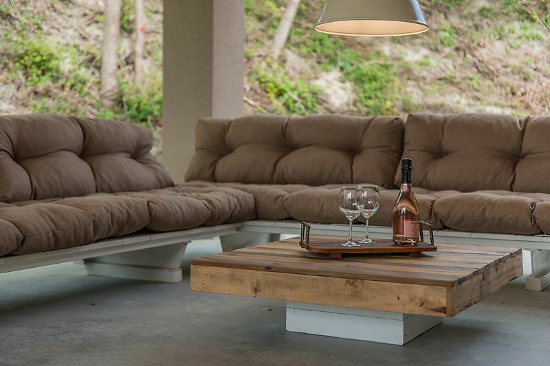 Holzsofa und Tisch im Freien, bequeme Couch und Pflanzen.