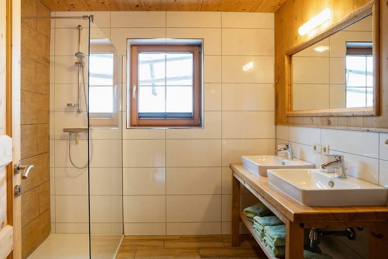Ein modernes Badezimmer mit Holzboden und Fenster.
