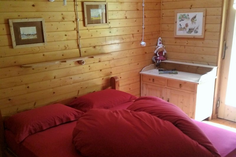 Gemütliches Schlafzimmer mit Holzmöbeln und Fensterblick.