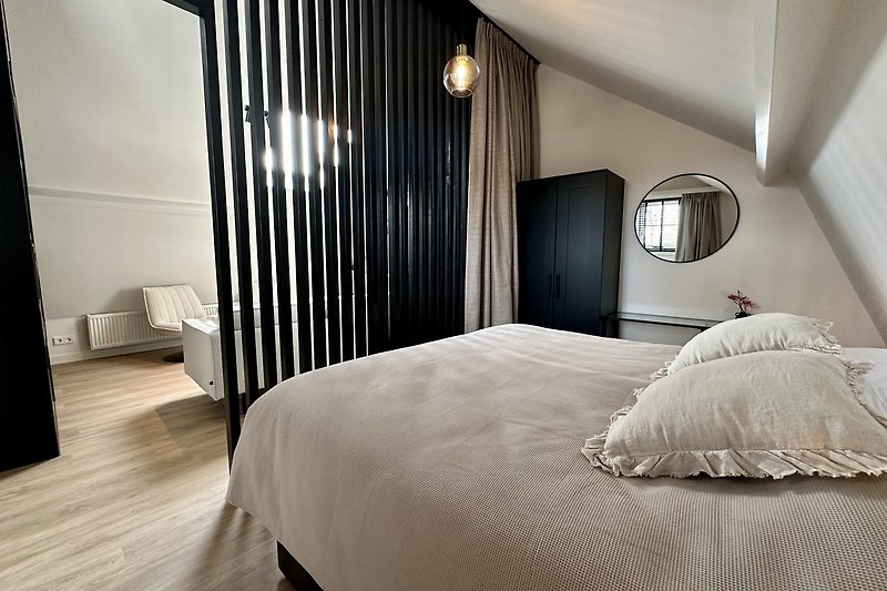 Schlafzimmer mit elegantem Holzbett und stilvoller Einrichtung.