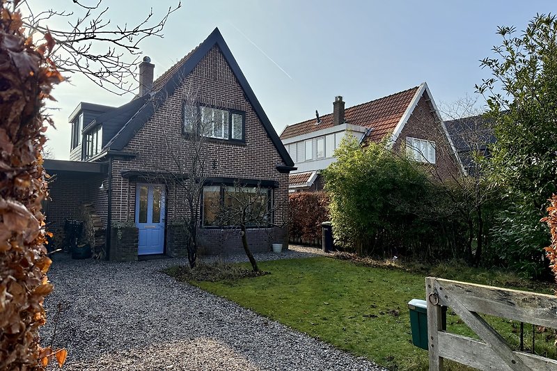 Gemütliches Landhaus mit Garten, Einfahrt und Zaun im Vorort.