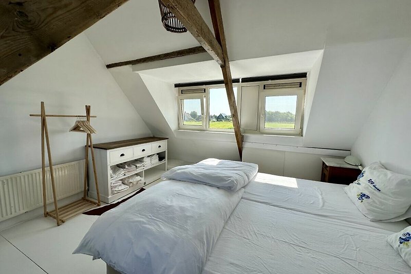 Gemütliches Schlafzimmer mit Holzbett und Lampen. Perfekt zum Entspannen und Ausruhen nach einem Tag am Strand.