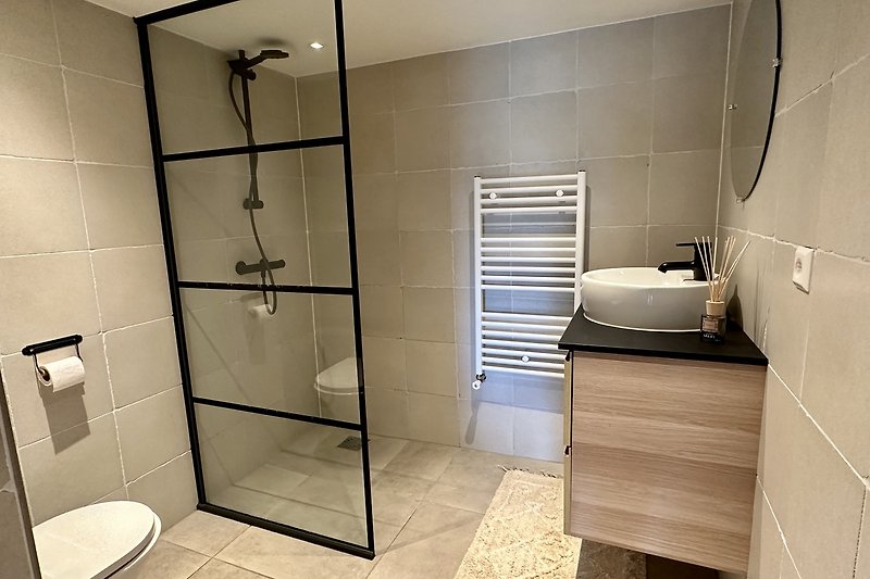 Modernes Badezimmer mit stilvoller Dusche und hochwertigen Armaturen. Entspannen Sie sich nach einem langen Tag.
