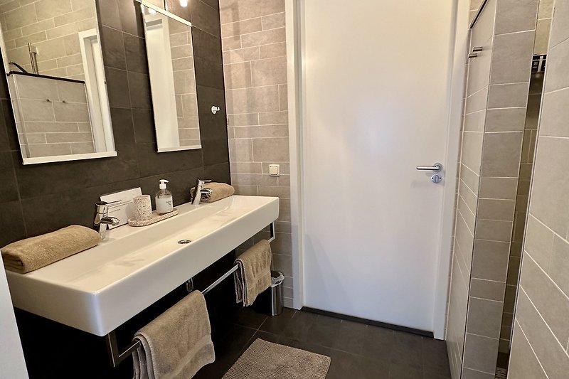 Modernes Badezimmer mit stilvollen Armaturen und Glaswaschbecken.