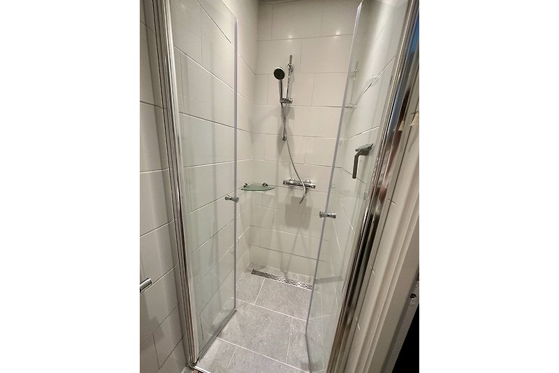 Schöne Dusche mit Glaswand und moderner Armatur.