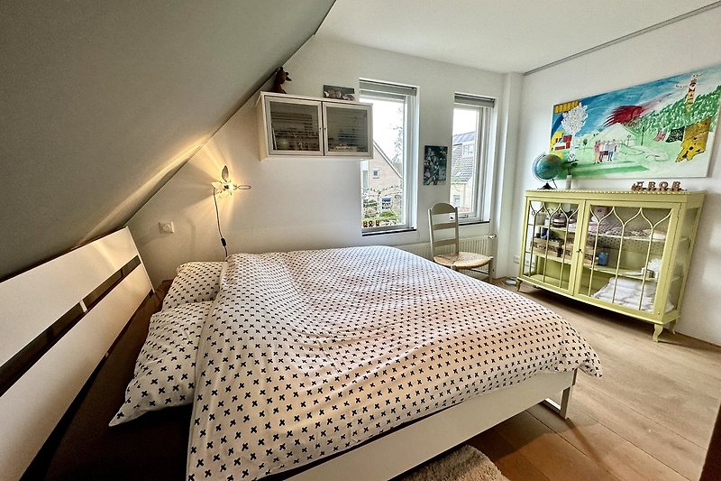 Stilvolles Schlafzimmer mit Holzbett und stilvoller Einrichtung.