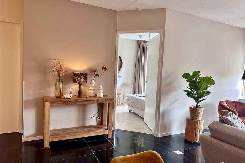 Willkommen in diesem stilvollen Wohnzimmer mit bequemen Möbeln und Pflanzen. Entspannen Sie sich und genießen Sie den Komfort!