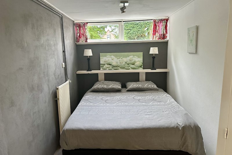 Gemütliches Schlafzimmer mit komfortablem Bett und stilvollem Bettgestell.