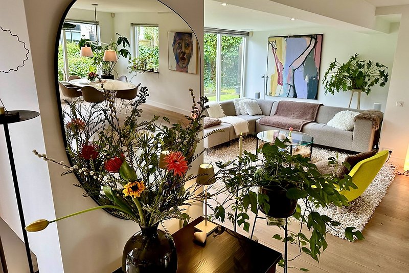Gemütliches Wohnzimmer mit stilvoller Einrichtung und Blumenarrangement.