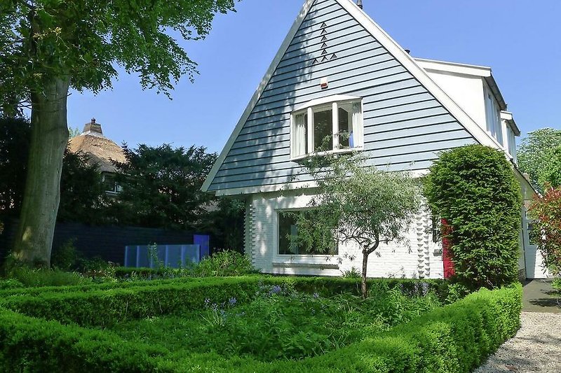 Historisches Haus mit gepflegtem Garten und einladender Fassade.