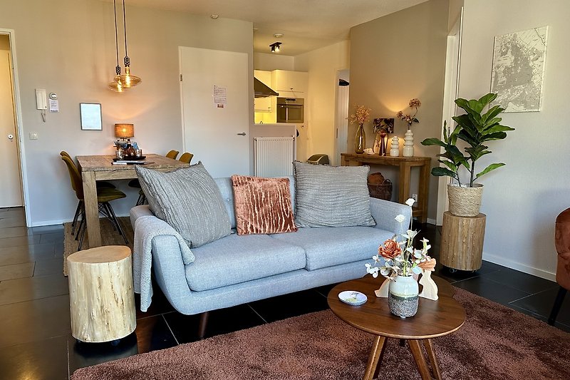Stilvolles Wohnzimmer mit bequemer Couch, Tisch und Pflanzen.