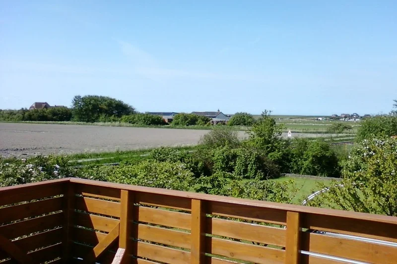 Balkon met een prachtig uitzicht op weilanden, dijken en de oude Hallig-vuurtoren.