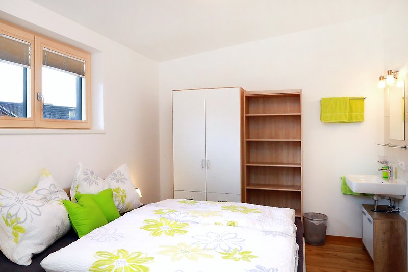 Gemütliches Schlafzimmer mit gelber Bettwäsche und Holzmöbeln.