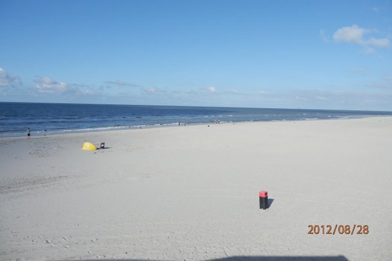 Die Weite des schönen Sandstrandes mit Meer im Hintergrund