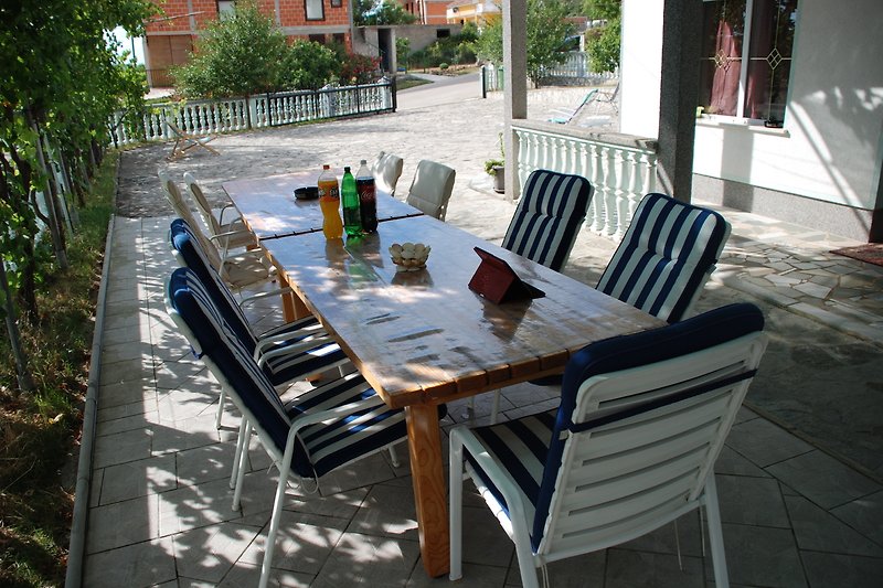 Schöne Terrasse mit Tisch, Stühlen und Pflanzen. Perfekt zum Entspannen und Essen im Freien.