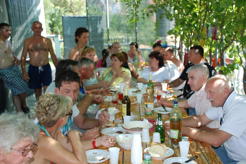 Genießen Sie eine Mahlzeit im Freien mit Freunden - Tisch, Stühle, Essen und Getränke.