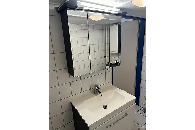 Schwarzer Spiegel, Wasserhahn, Waschbecken, Licht - modernes Badezimmer.