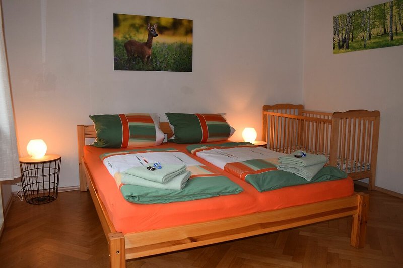 Hochparterre: Familienschlafzimmer mit Babybett und Holzmöbeln.