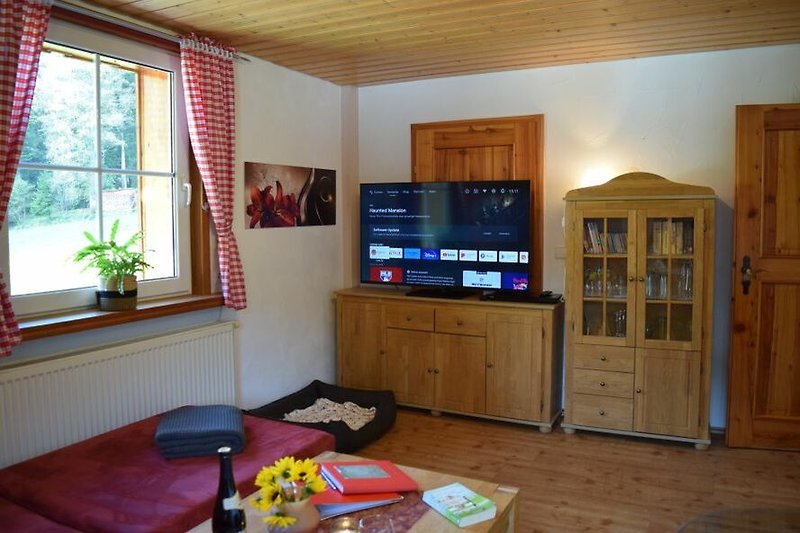 Mittelstock: Gemütliches großes Wohnzimmer mit Holzmöbeln, Kaminofen und großen TV