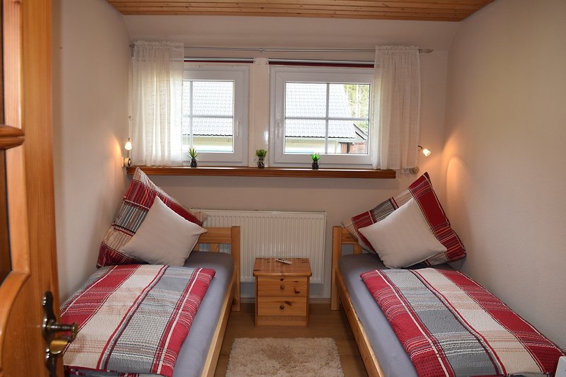 Schlafzimmer mit Holzmöbeln,mit zwei  bequemem Betten und stilvollem Interieur.