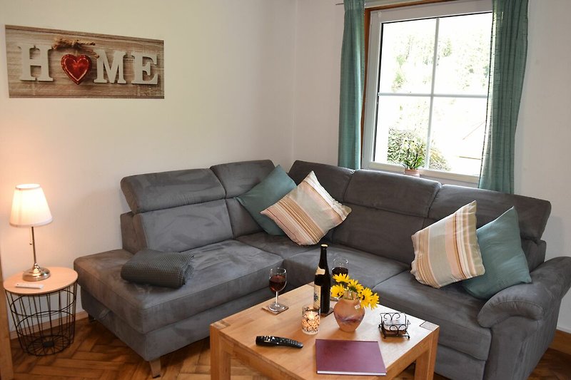 Hochparterre: Gemütliches Wohn-Esszimmer mit Holzmöbeln und bequemer Couch.
