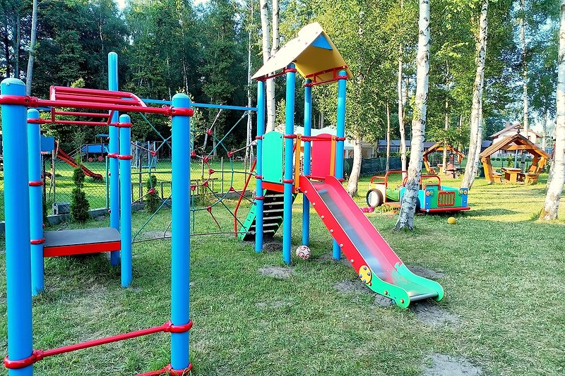 Spielplatz mit Rutsche, viel Grün und Spaß im Freien!