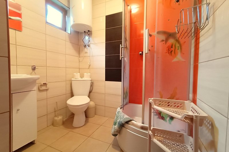 Modernes Badezimmer mit Keramik-WC, Bidet und Fensterblick.