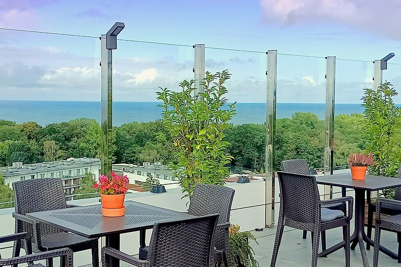 Café-Bar auf der Dachterrasse mit Panoramablick auf das Meer und die Stadt mit tropischem Wintergarten