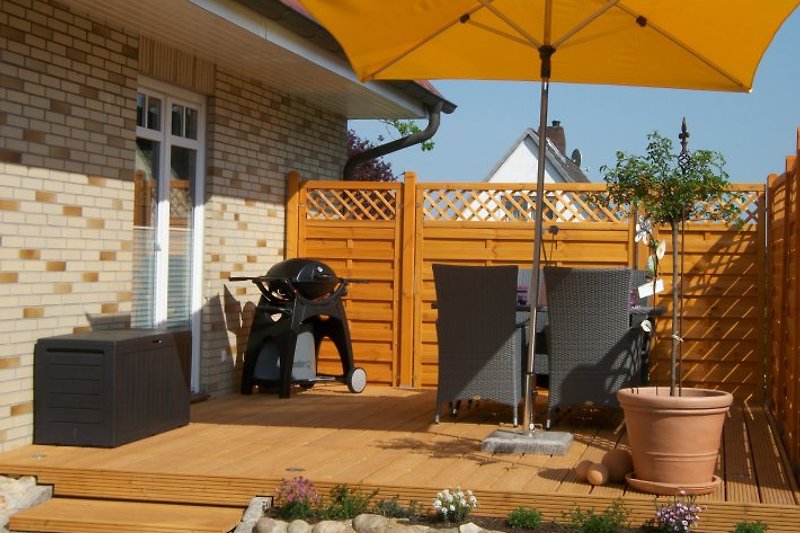 Terrasse mit Grill und Gartenmöbeln