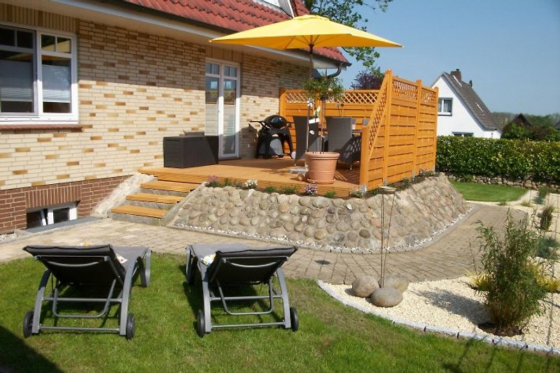 Terrasse mit Gartenmöbeln und Grill