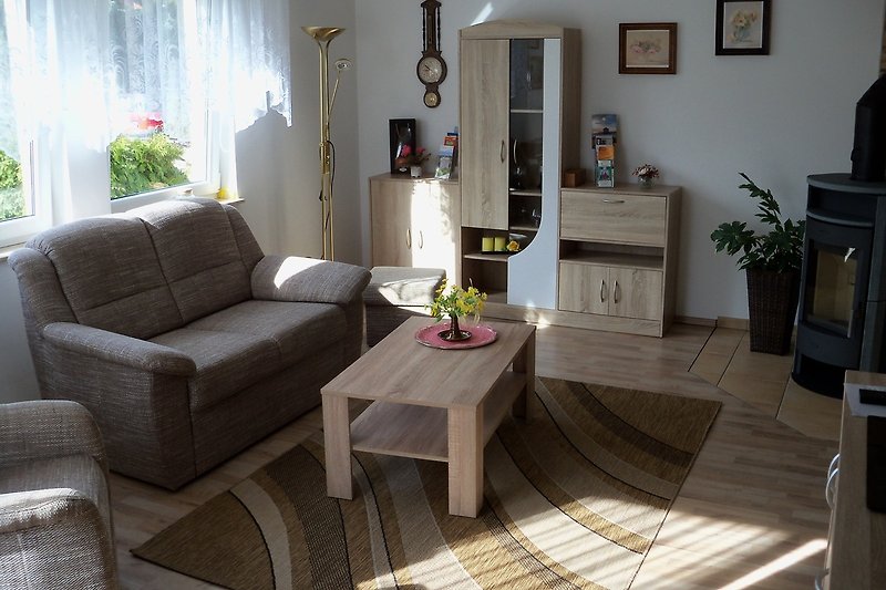 Wohnzimmer mit bequemer Couch, Tisch und Anbauwand