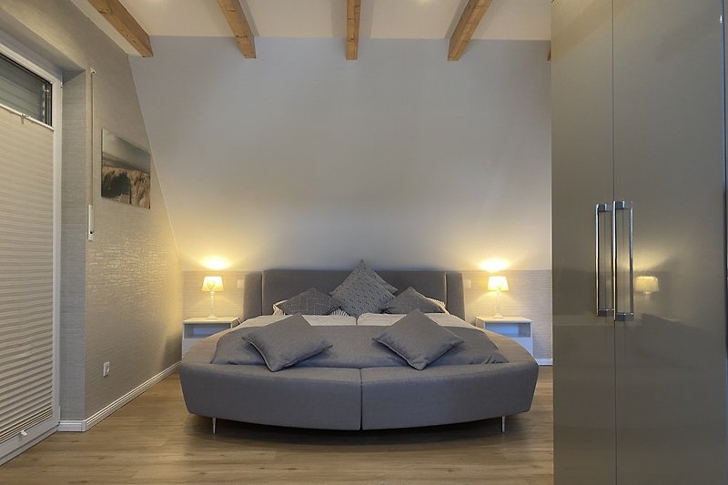 Stilvolles großes Schlafzimmer mit luxuriösem Bett und elegantem Interieur.