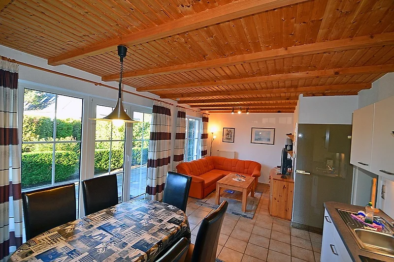 Woonkamer met een comfortabele bank, een salontafel en een televisie in een modern appartement.