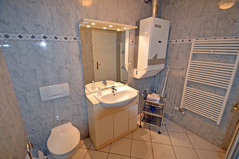 Badezimmer mit Spiegel, Waschbecken und Armatur.