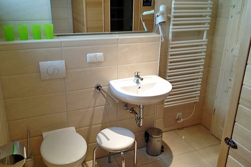 Gemütliches Badezimmer mit lila Fliesen, Holzboden und stilvoller Beleuchtung.