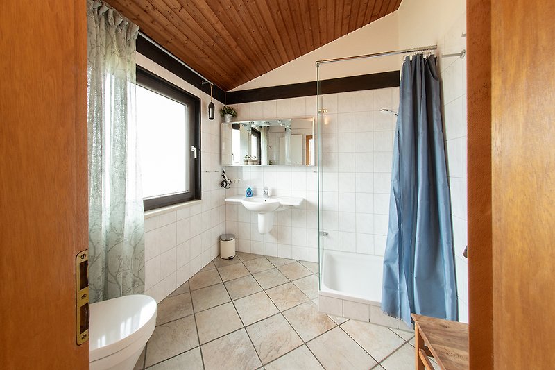 Modernes Badezimmer mit Holzdetails und Fensterblick.
