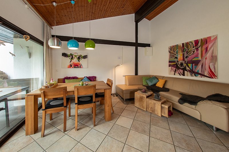 Wohnzimmer mit Holzbalken, gemütlicher Einrichtung und Kunst.