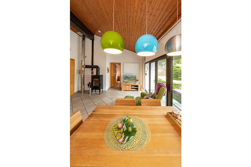 Wohnzimmer mit Holzboden, Stühlen, Pflanzen & Fenster. Gemütliche Atmosphäre.