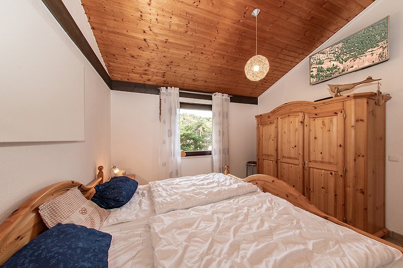 Gemütliches Schlafzimmer mit Holzbett und bequemer Bettwäsche.