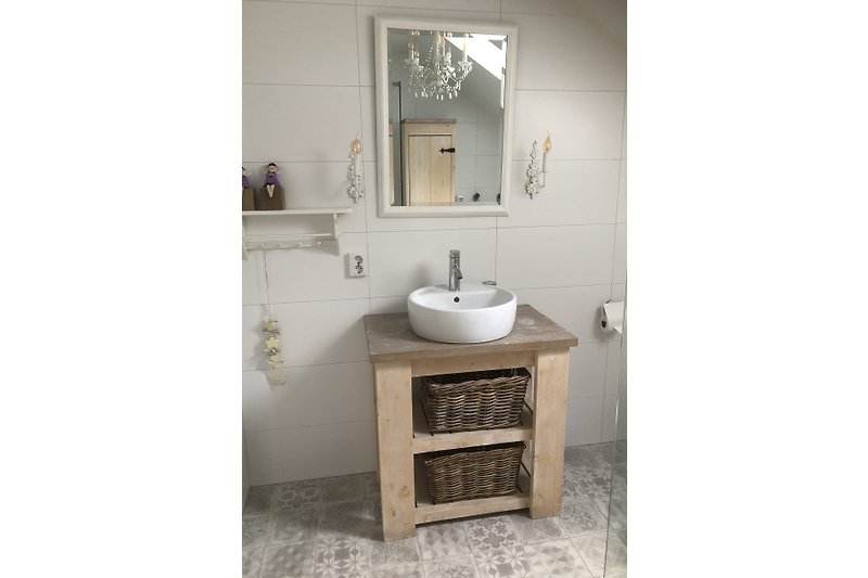 Badezimmer mit Spiegel, Holzregal, Waschbecken und Fenster.
