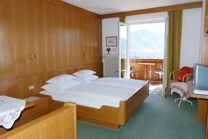 Zimmer von Ferienwohnung 11 mit Sitzecke, Telefon, Sat-Tv, Safe und Südbalkon