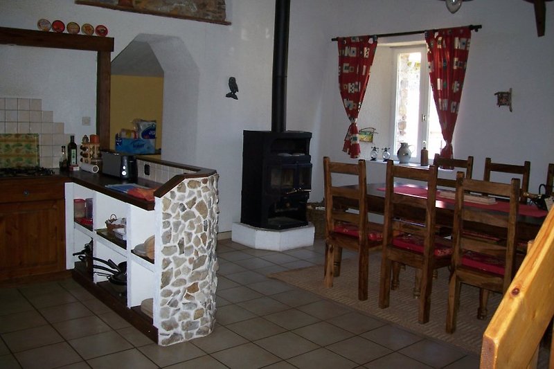 Küche mit Esstisch und Kaminofen
