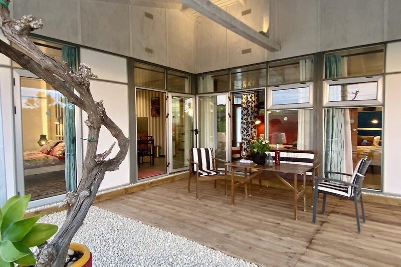 Wohnzimmer mit Holzarchitektur, Pflanzen und Kunst.