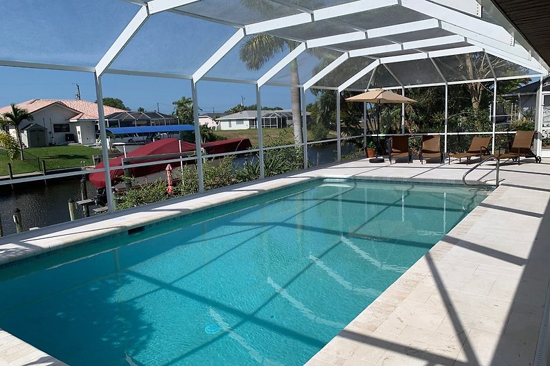 Luxuriöses Resort mit Pool, Sonnenschirmen und Outdoor-Möbeln.
